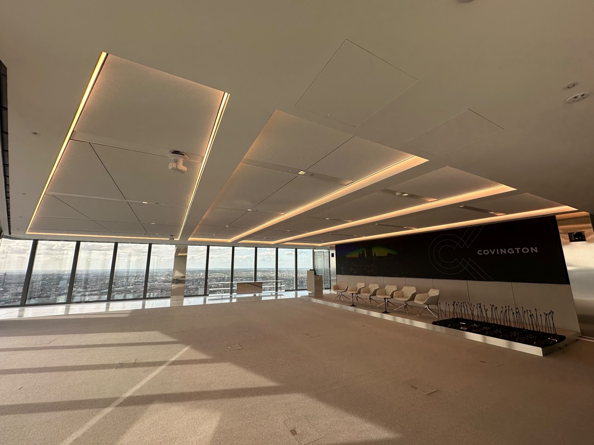 Auditorium at 22 Bishopsgate showing RAL 9010 ceiling rafts with recessed REVEAL 200mm channels and panoramic City views